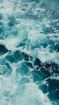 Dynamic shot of ocean waves crashing at Punta Uva, showcasing vivid blue waters and sea foam.