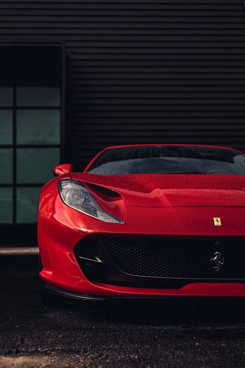 Red Ferrari Car Parked outside a Building