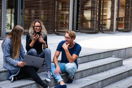 Drie Personen Zittend Op De Trap Met Elkaar Praten