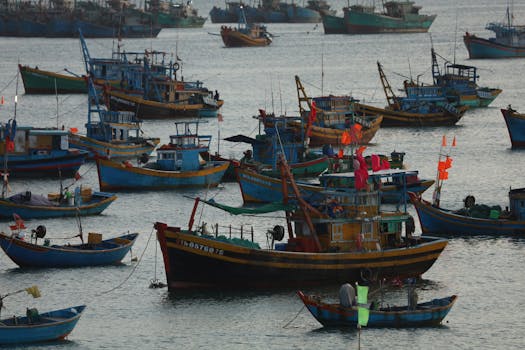 A vibrant scene of traditional fishing boats in a bustling harbor at sunset.