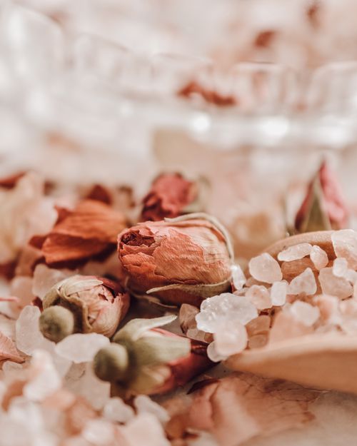 Free Pink rose buds and bath salts create a serene spa-like atmosphere, perfect for relaxation. Stock Photo