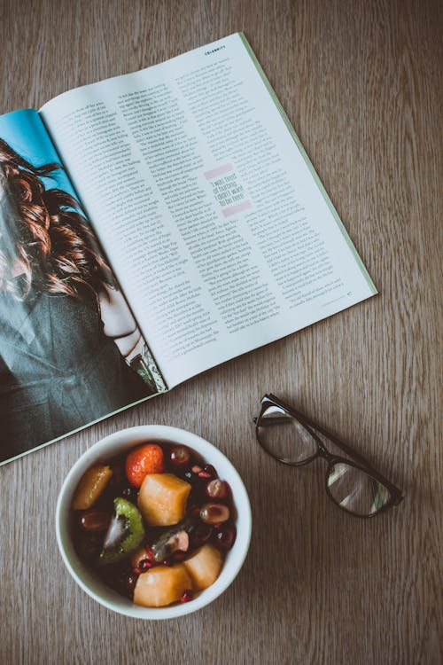 Lunettes à Côté D'un Bol De Nourriture Et D'un Magazine Sur La Table