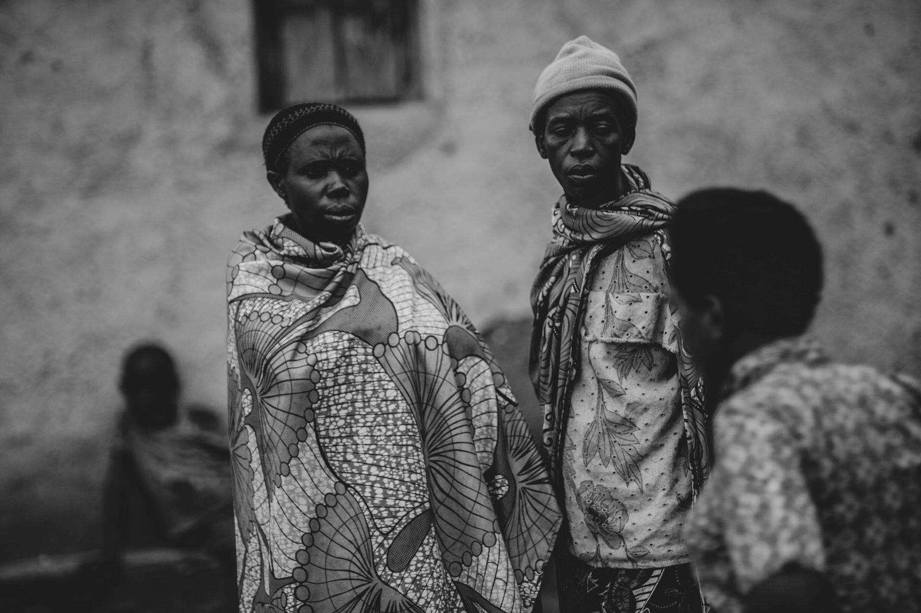 Group of adults in traditional African clothing, captured in black and white.