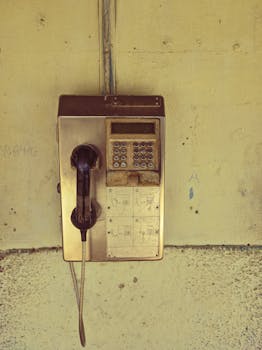 A nostalgic vintage telephone booth mounted on a wall in Holguín, Cuba, evoking classic charm.