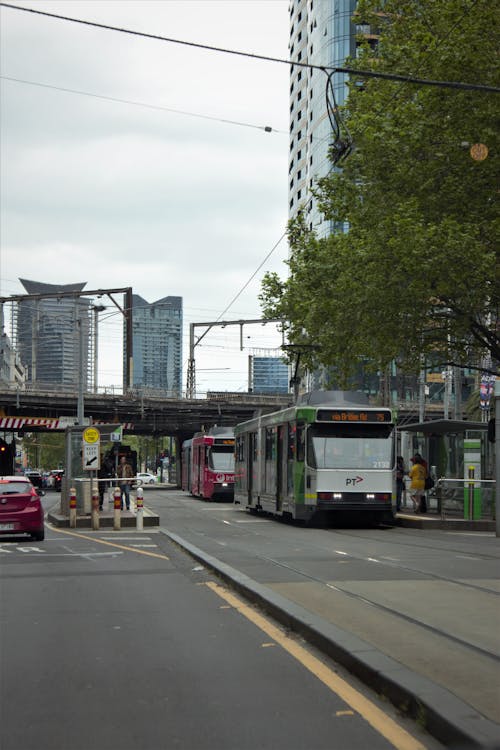 Tram on a Stop Near City Buildings