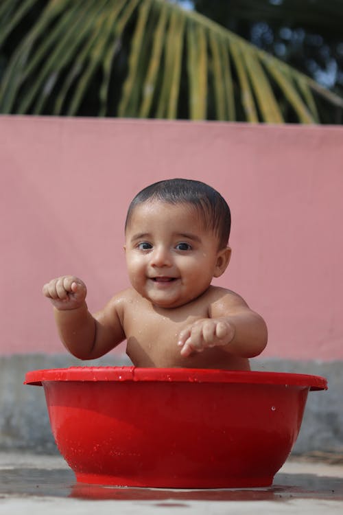 Child Bathing in Big Red Bowl