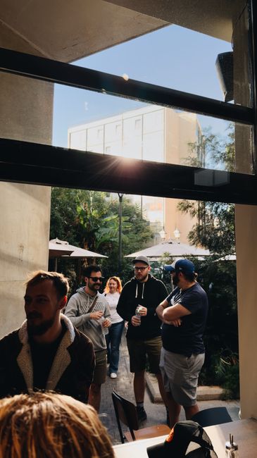 Group of adults enjoying a sunny day at an outdoor cafe.