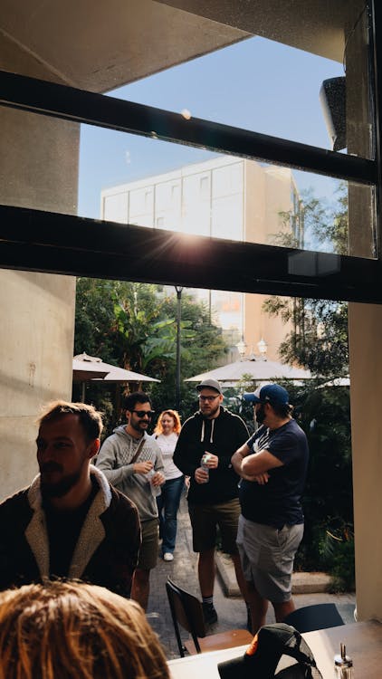 Free Group of adults enjoying a sunny day at an outdoor cafe. Stock Photo