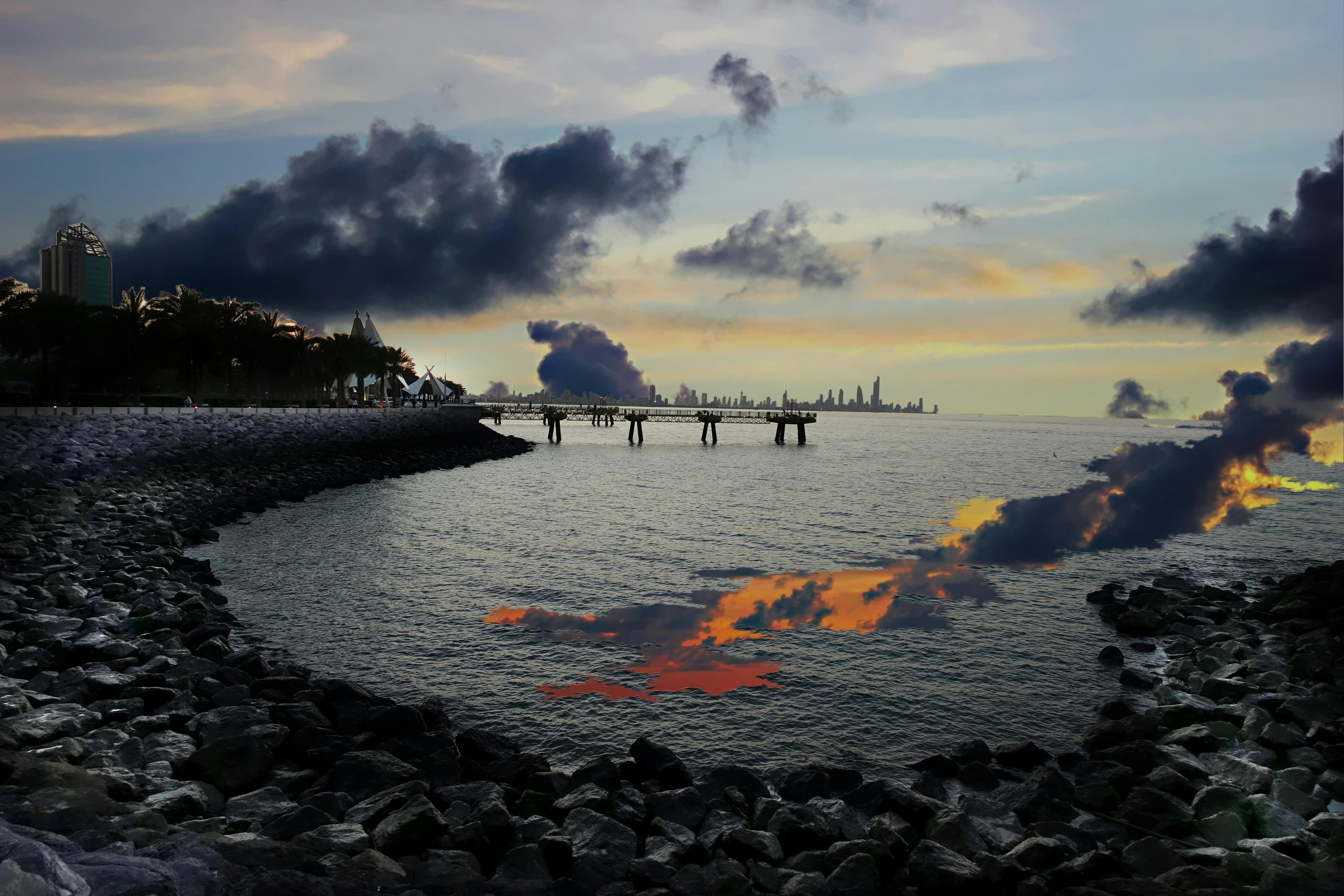 迷人的日落映照着海景、岩石海岸和遥远的城市天际线