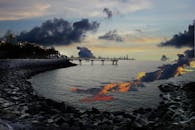 迷人的日落映照着海景、岩石海岸和遥远的城市天际线