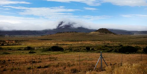 Free A serene landscape with a misty mountain and grassy fields under a bright sky. Stock Photo