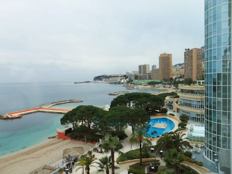 View of Monaco's coastline featuring luxury hotels, beach, and city skyline.