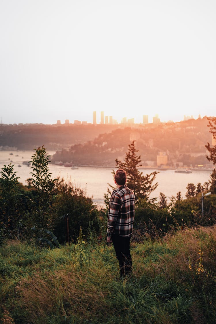 Man Standing On A Hill And Looking On A City