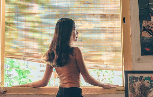 Femme Debout à Côté De La Fenêtre