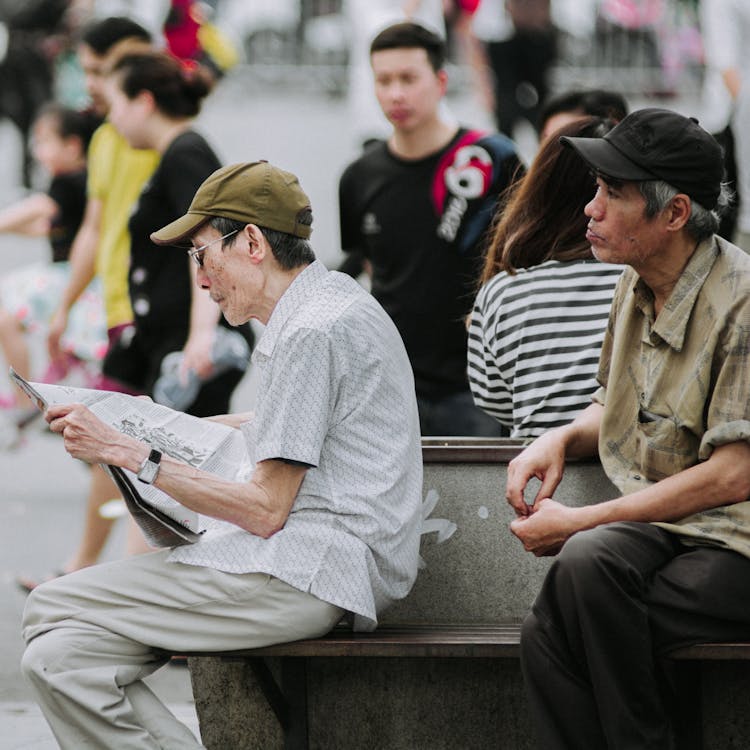 Selective Focus Photography Of Men Sitting On Chair Outdoor