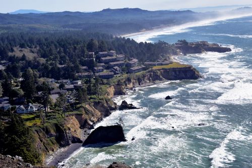 Free A stunning coastal view of a town perched on cliffs by the sea with waves crashing below. Stock Photo