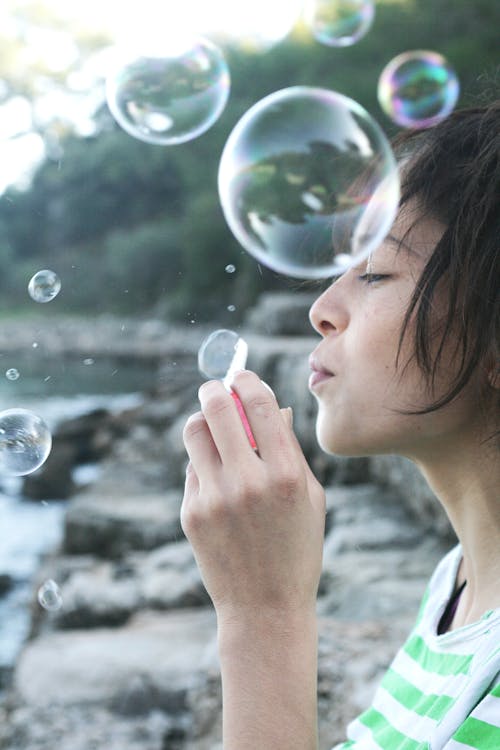 Photography of Woman Blowing Bubbles