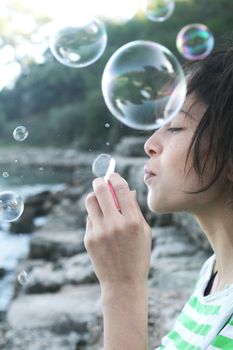 一位快乐的年轻女子在户外吹泡泡，捕捉夏日的乐趣与幸福