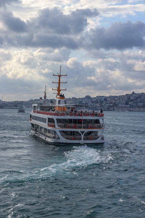 White and Red Ship on Sea Under White Clouds and Blue Sky