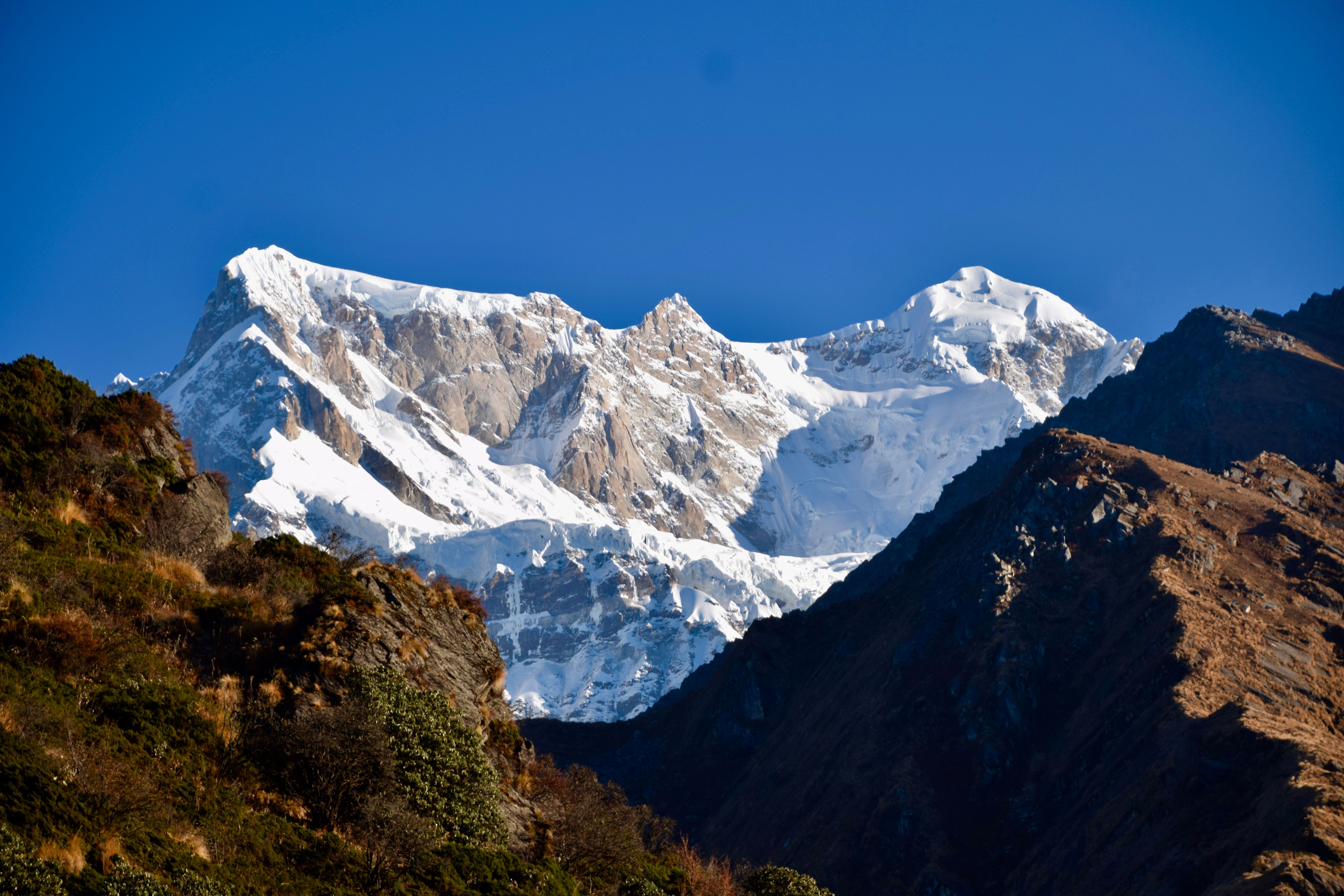 Breathtaking view of a snow-covered mountain peak against a clear blue sky.