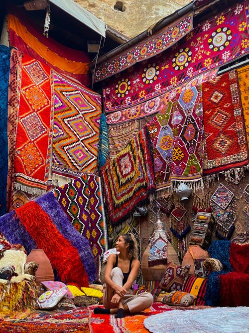 Free Explore the vibrant display of intricate Turkish rugs in a lively bazaar setting. Stock Photo