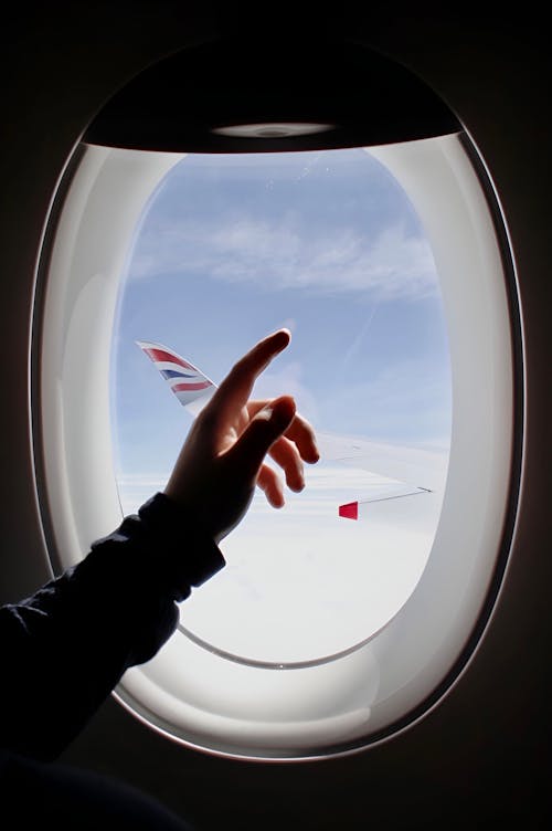 A Person's Hand on the Airplane Window