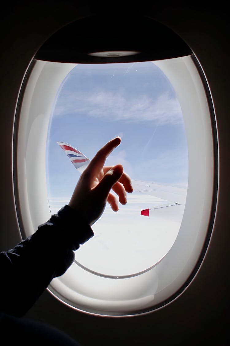 A Person's Hand On The Airplane Window