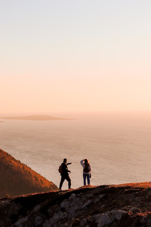 Silhouette of Man and Woman on a Cliff 