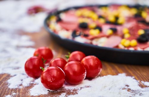 Free Cherry tomatoes and mixed ingredients ready for homemade pizza baking. Stock Photo