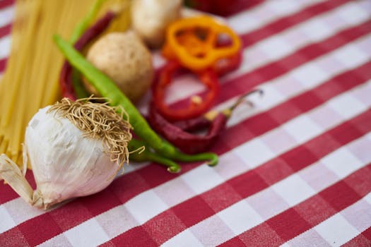 A vibrant assortment of vegetables and pasta on a red and white plaid tablecloth.