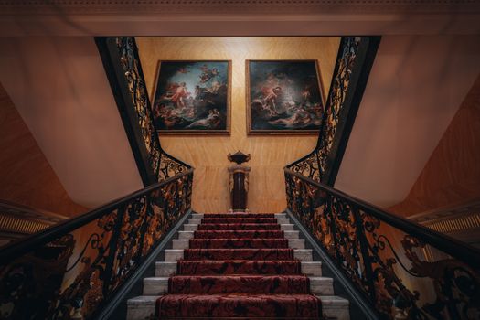 Luxurious staircase in London adorned with classic art, offering a glimpse into historic architecture.