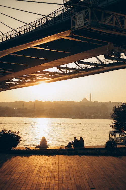 People Sitting under Halic Bridge at Sunset