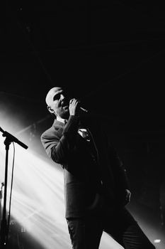 Captivating black and white photo of a man singing on stage during a live concert in Istanbul, Turkey.