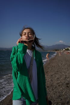 Young woman in green enjoying a sunny day at the beach in Larnaca, Cyprus.