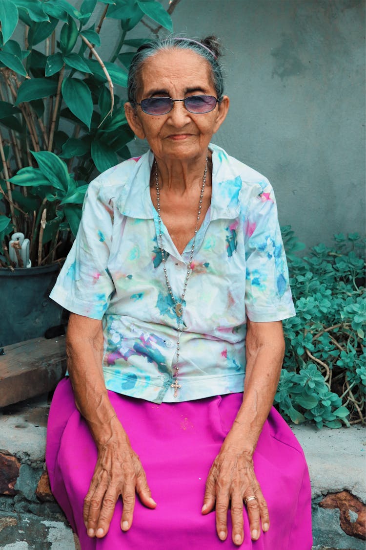 Elderly Woman Sitting On A Plant Box