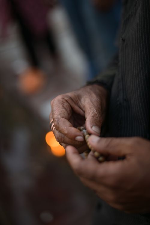 Free Hands holding prayer beads in a serene setting, emphasizing spirituality and focus. Stock Photo