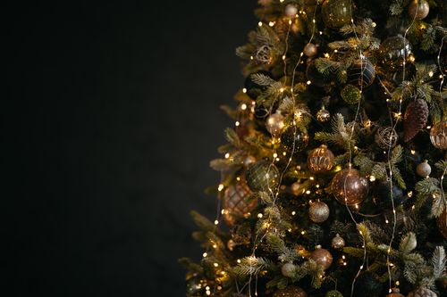 Free Close-up of a beautifully decorated Christmas tree with glowing lights and ornaments. Stock Photo