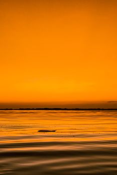 Tranquil sunset ocean view with vibrant orange sky reflecting on calm waters in Mumbai.