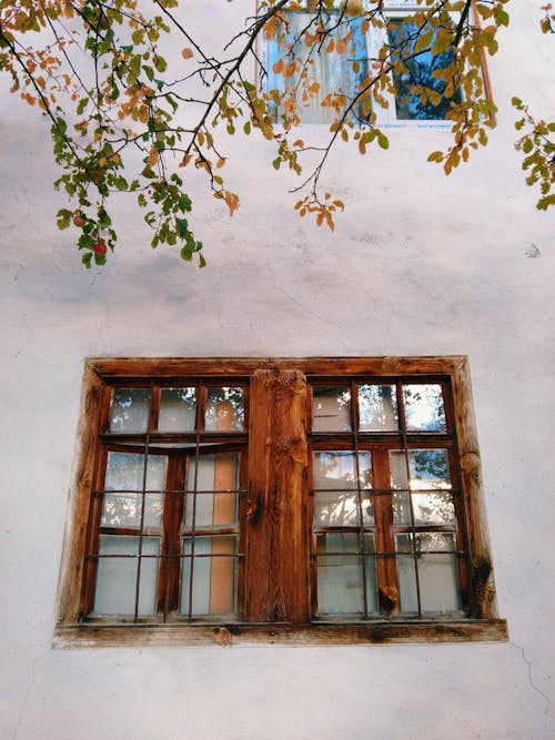 A Low Angle Shot of a Wooden Window on a Concrete Wall