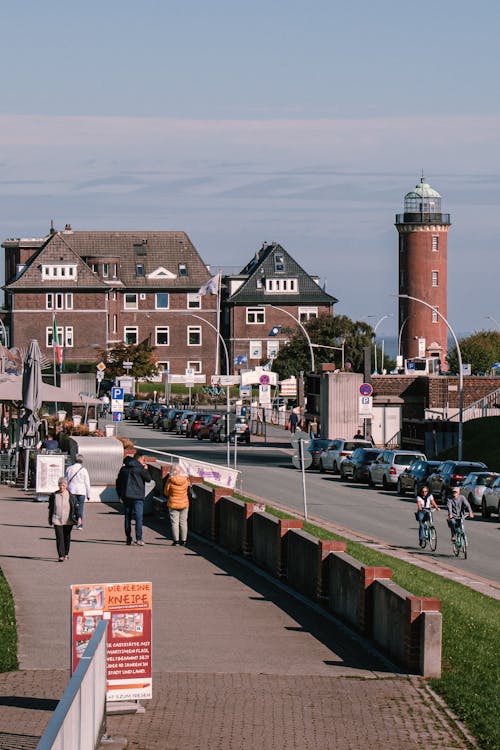 People Walking on Sidewalk Near Brown and White Concrete Building