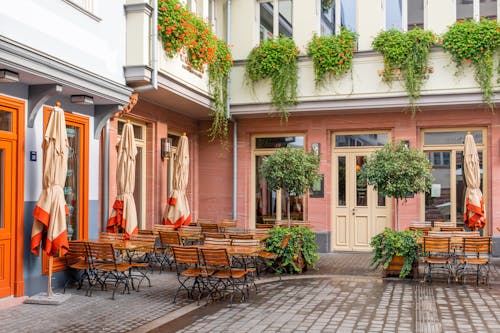 Brown Wooden Chairs and Tables Outside a Building