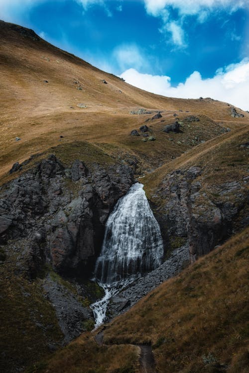 Waterfalls on Mountainside Under Blue Sky