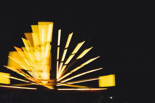 Abstract image of moving yellow lights on a dark background, creating a dynamic and vibrant pattern.