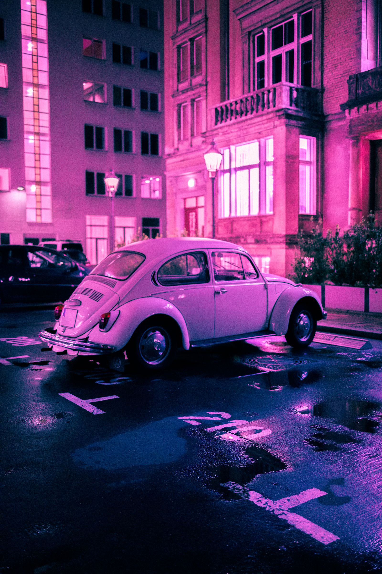Carro clássico refletindo luzes neon em uma rua noturna
