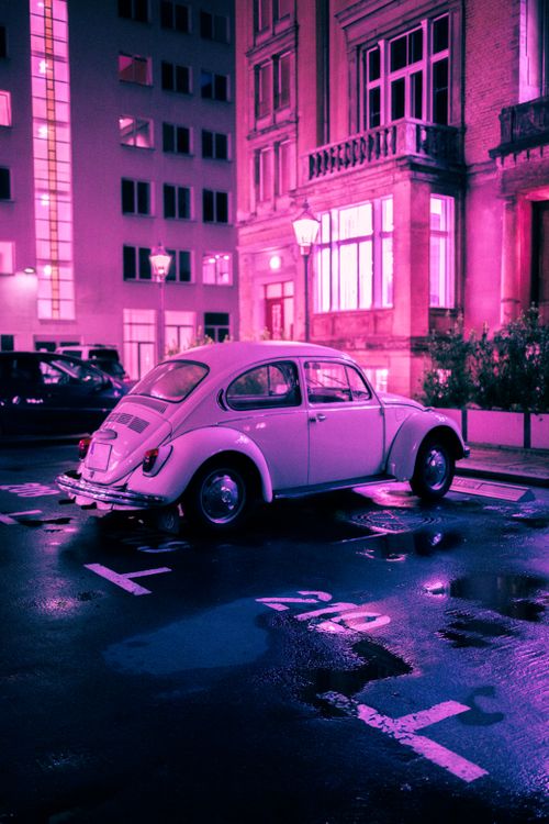 Free Classic car reflecting neon lights in Berlin night street scene. Stock Photo