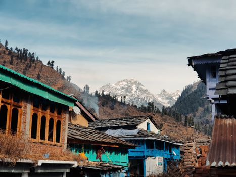 Charming rural village with traditional architecture against backdrop of majestic mountains.