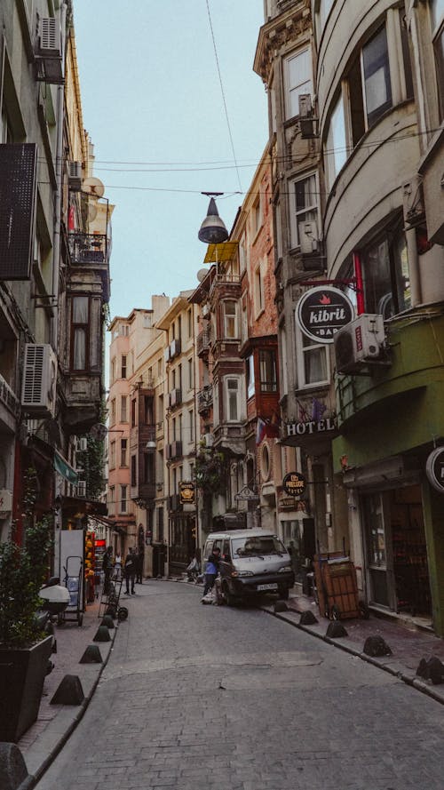 People Walking on the Street Between Buildings