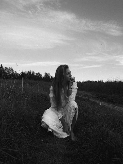 Woman in White Dress on Grassland in Black and White