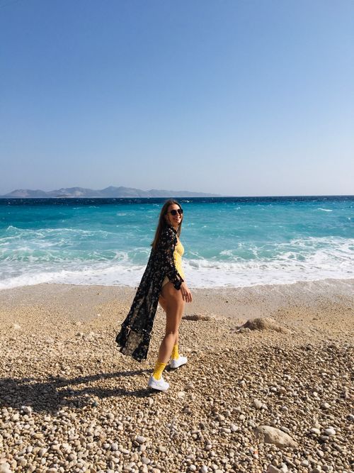 Free A woman enjoys a sunny day on a pebbled beach in Kaş, Antalya, Turkey. Stock Photo