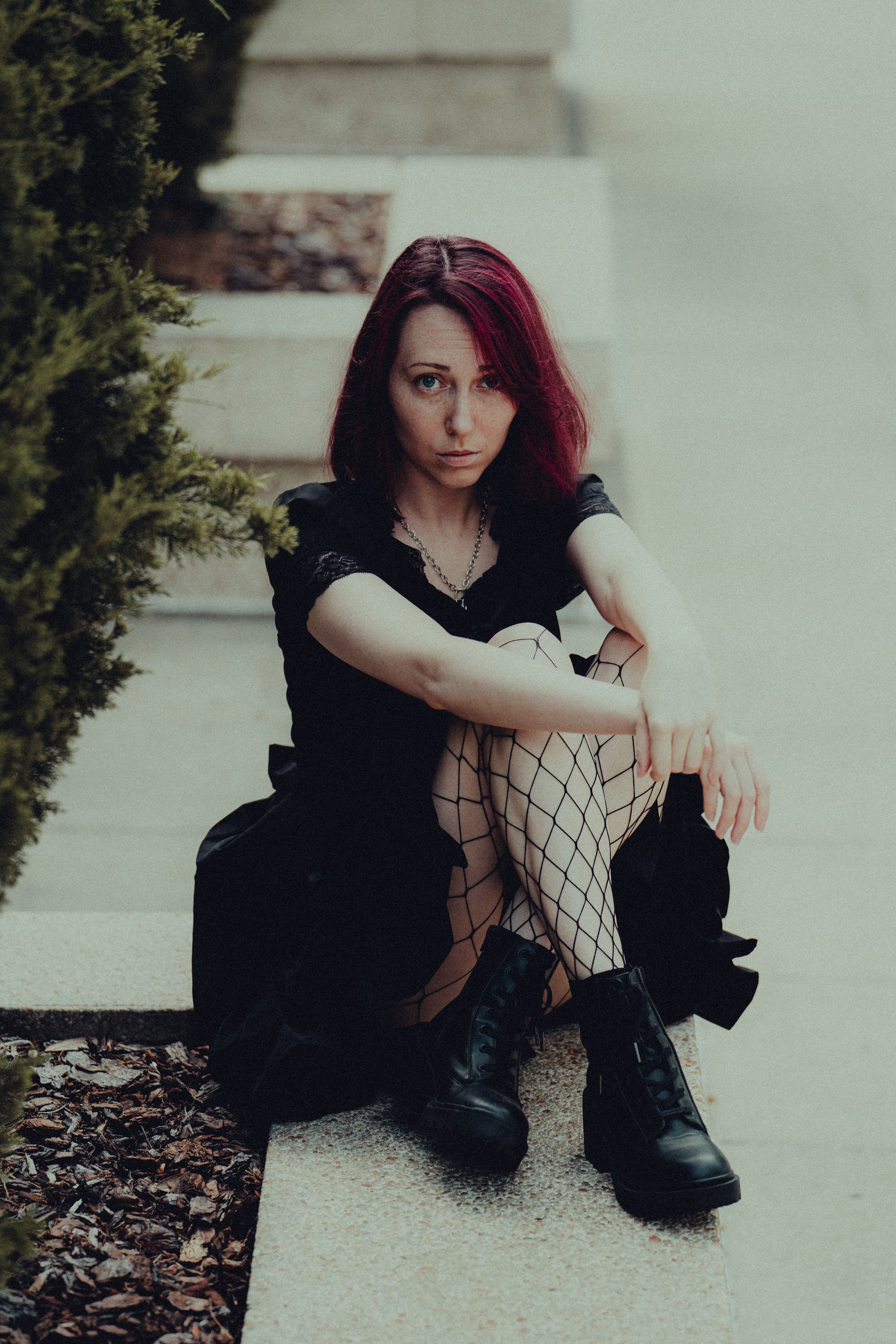 Woman in Black Dress Sitting on Gray Concrete Floor · Free Stock Photo